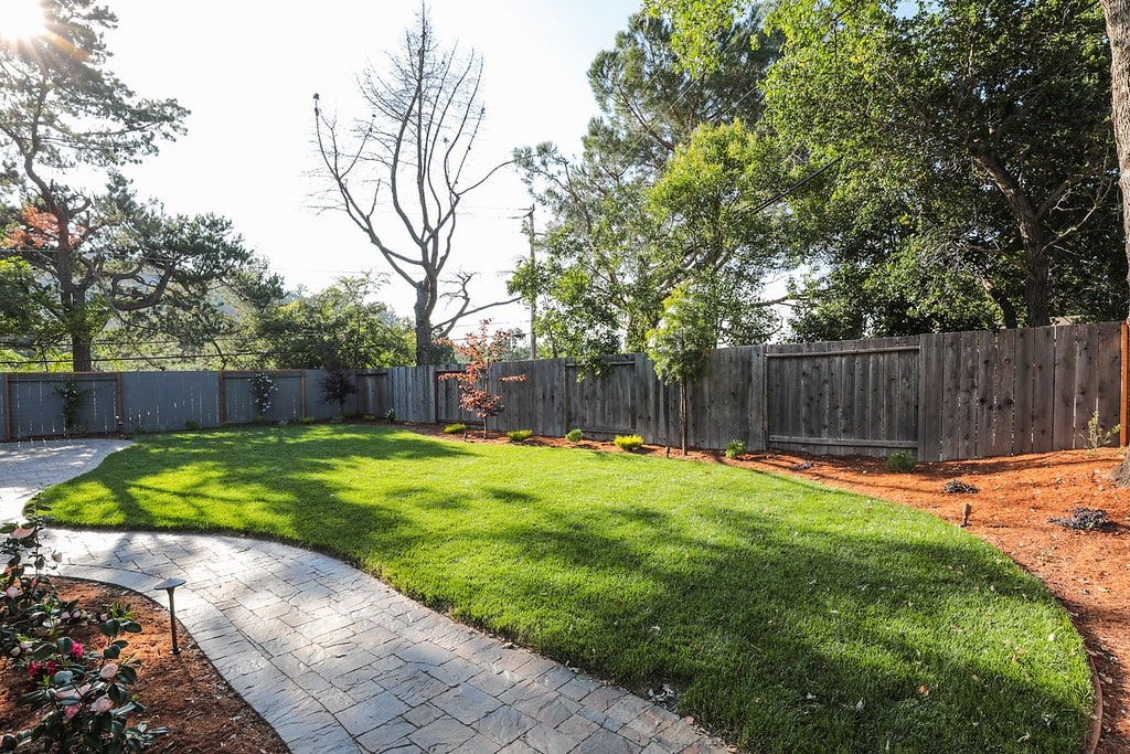 Landscaped backyard with mulch, lawn, paver pathway and lights